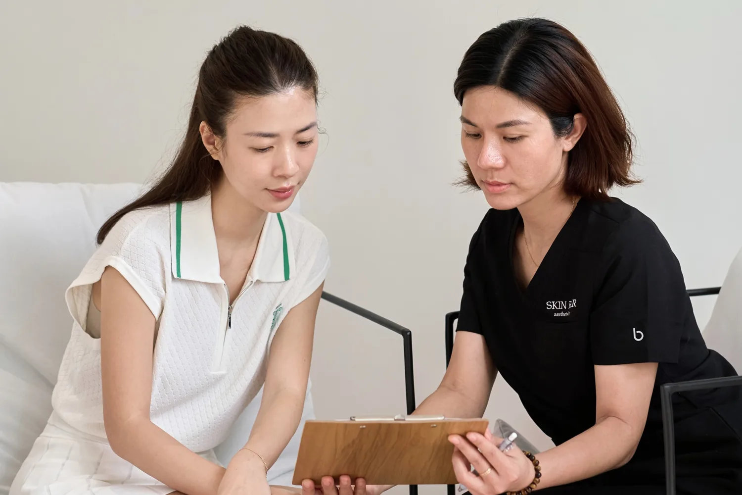 A SKIN BAR specialist discussing treatment options with a guest.